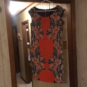 Bright orange dress with black leaf pattern and khaki background mixed in.